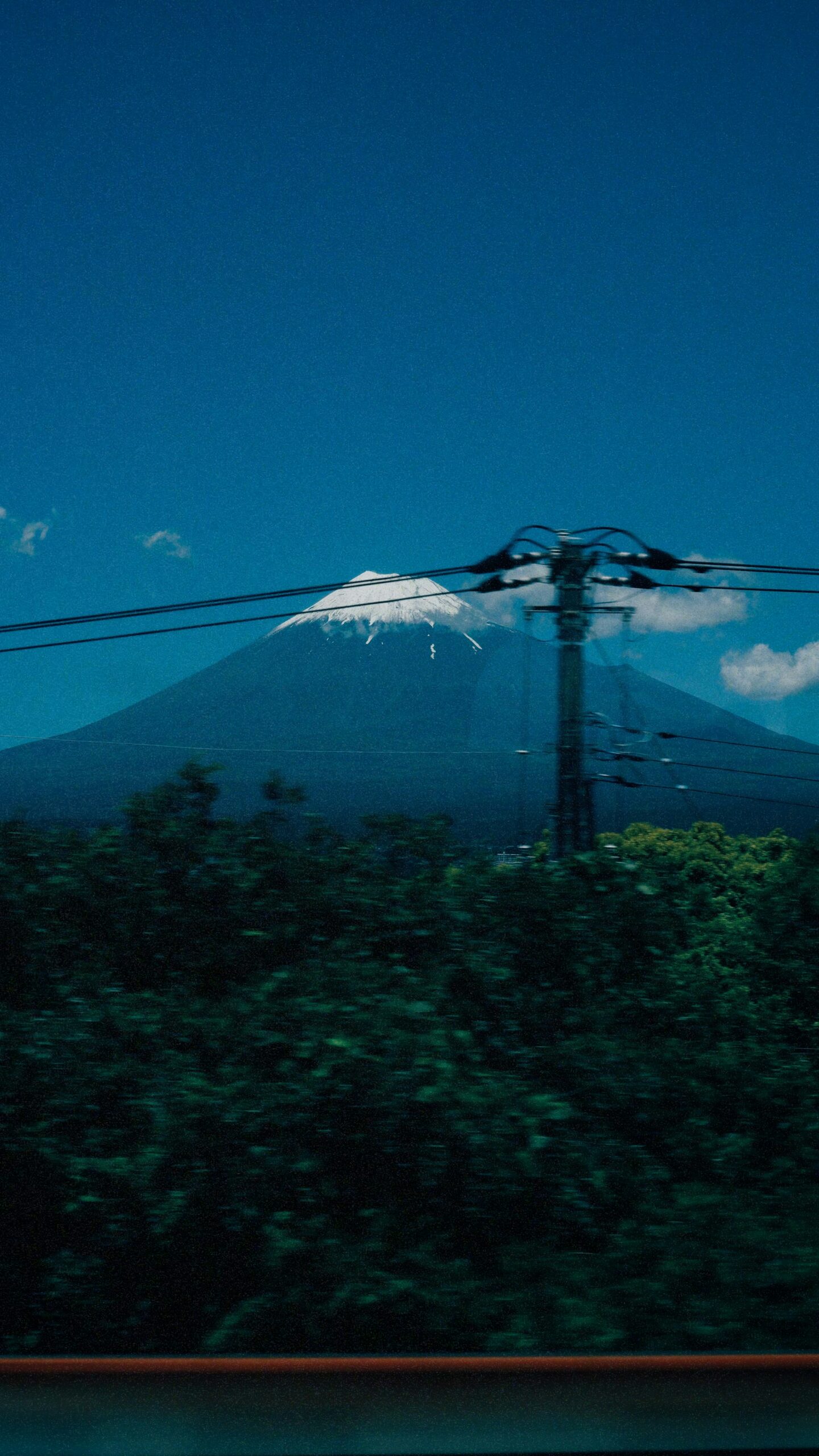 Image of Mt. Fuji from a train with blue skyline